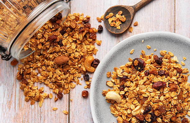 istock Granola cereal scattering from jar onto plate 2242309346