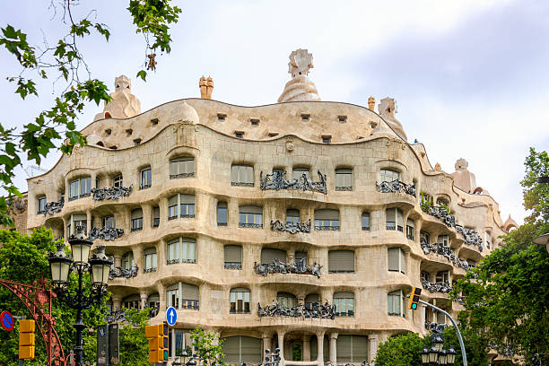 Barcelona, Spain - June 13, 2025: Casa Mila, also known as La Pedrera, showcases Antoni Gaudi’s distinctive undulating stone facade and wrought-iron balconies in Barcelona, Spain.