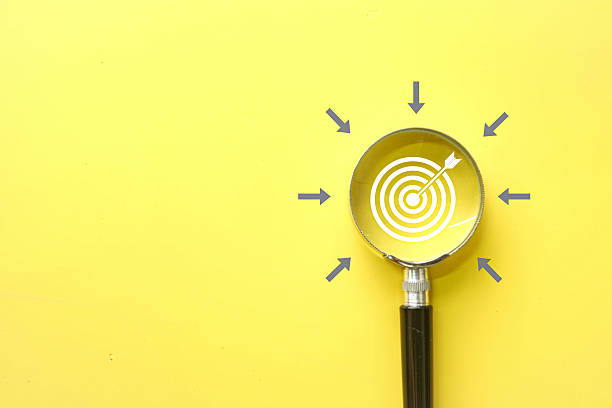 Goals, Focus, Achievement,Precision, Strategy concept.,Dartboard icon under Magnifier glass over yellow background.,copyspace.
