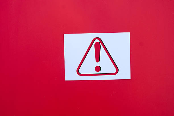 Red Caution sign warning of potential hazards on white paper over red background with copyspace.,Warning caution,potential hazards, emphasizing safety, awareness, and risk prevention concept.