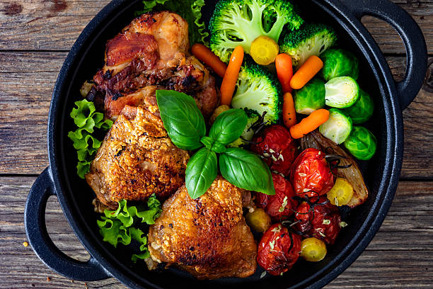 istock Baked chicken thighs with vegetables in baking dish on wooden table 2242313250