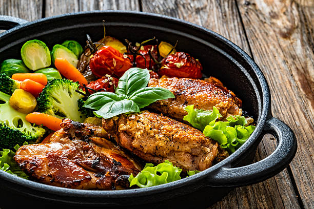 istock Baked chicken thighs with vegetables in baking dish on wooden table 2242313277