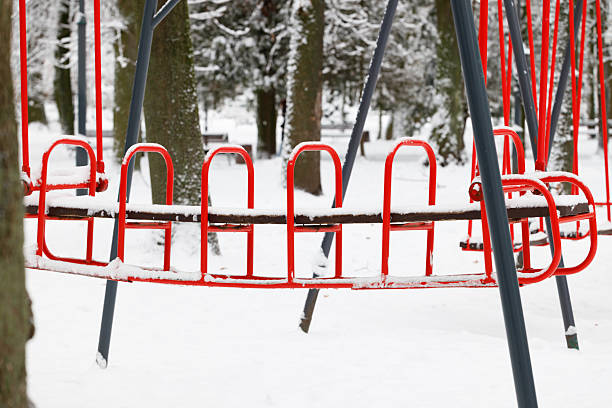 metallic carousel swing USSR made amusement park snowy trees outdoor environment space December day time
