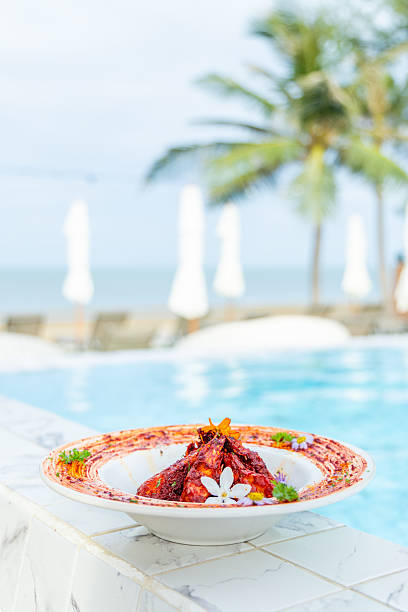 Gourmet seafood dish by luxurious poolside, tropical setting, vibrant