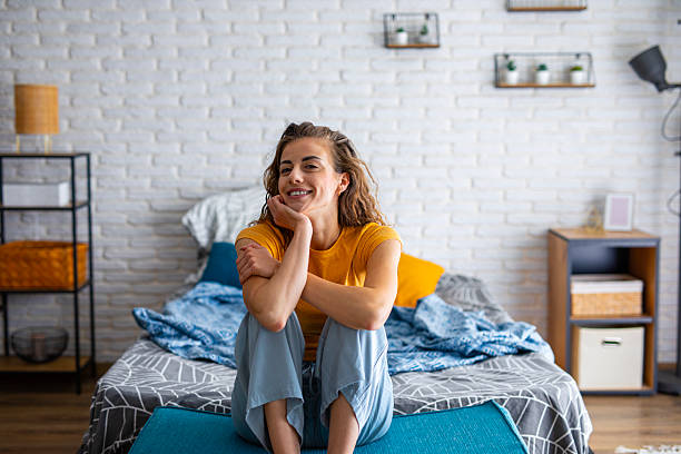istock Rested woman sitting on bed in the morning light 2242322390