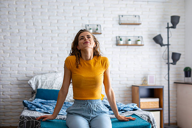 istock Rested woman sitting on bed in the morning light 2242322407