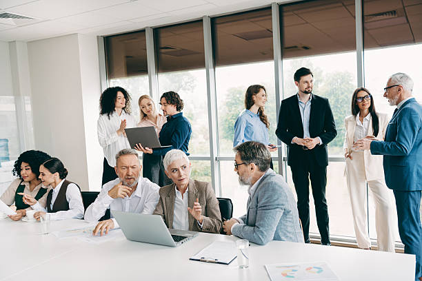 istock Diverse team of businesspeople collaborating in a modern office environment, discussing strategies and teamwork around a table 2242324087