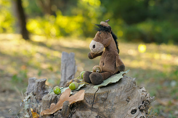 Close-up of a soft brown plush horse toy sitting against a beautiful blurred background, creating a warm and gentle composition.
