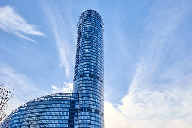 Modern glass skyscraper with curved facade reflecting sunlight and blue sky. Sky Tower building in Wroclaw, Poland. Contemporary architecture