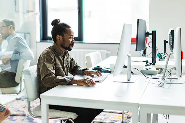 istock Young adult man working at modern coworking using computer 2242327253