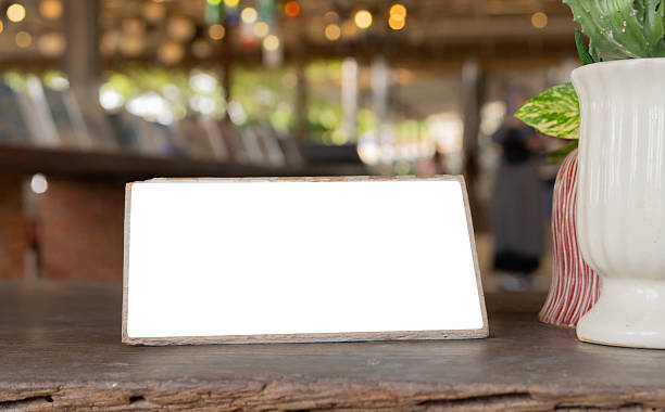 Wooden table in a bar or cafe with a menu frame for showcasing text perfect for a copy space.