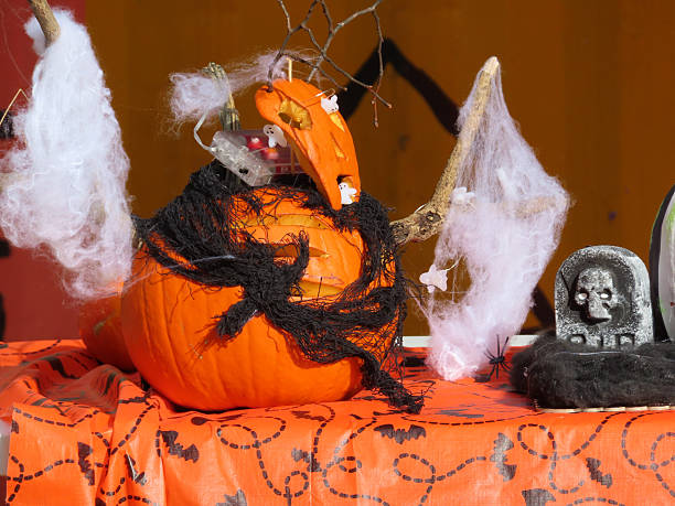 istock Creative Halloween pumpkin decorated with cobwebs, ghosts, spiders and fabric on festive orange tablecloth 2242328668