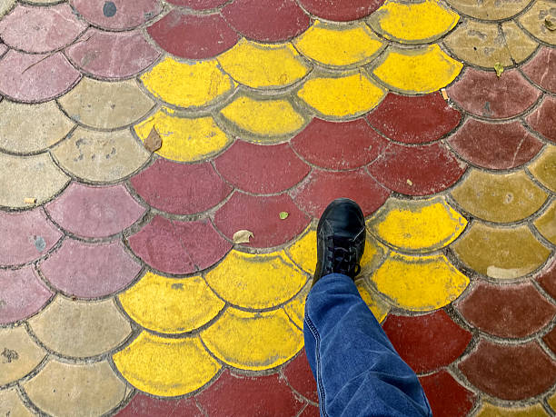 High angle close-up view of person walking over a colorful tiled floor