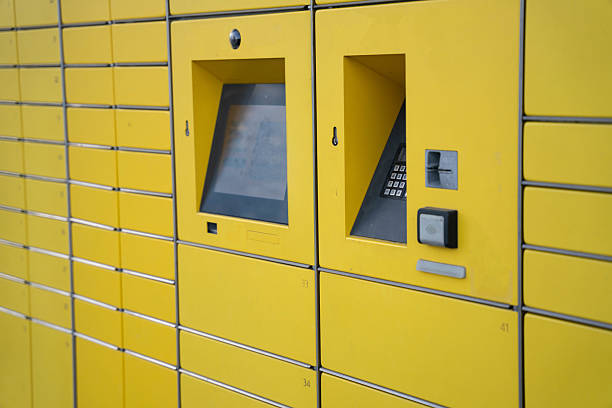 A row of yellow lockers with numbers on them. The lockers are open and empty
