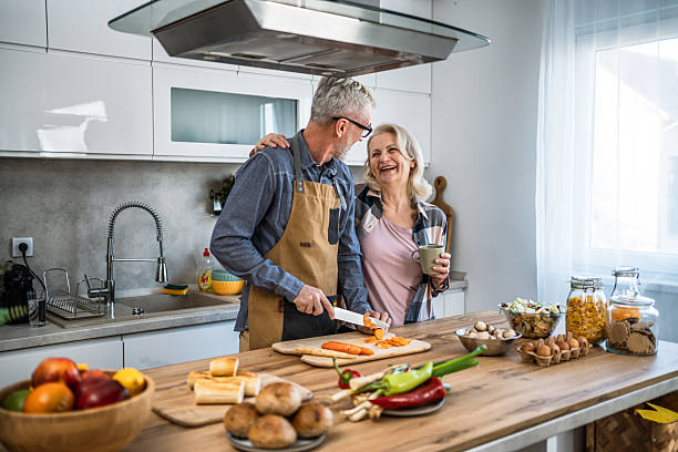 istock Happy senior couple cooking together in kitchen 2242330346