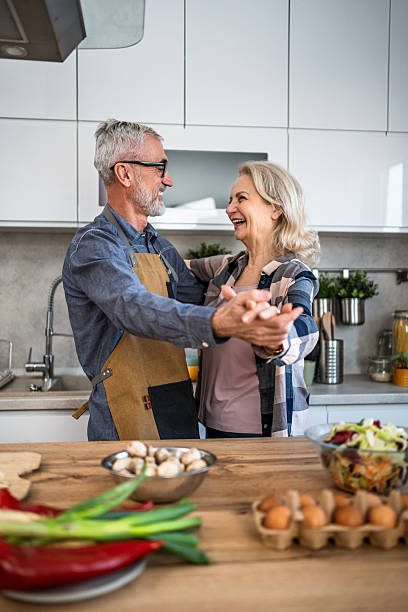 istock Happy senior couple dancing together in kitchen while cooking 2242330474