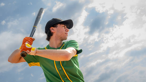 istock Caucasian Baseball Player in Green Uniform Ready to Swing Bat 2242331517