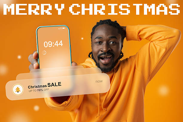 istock Excited man celebrates Christmas while showcasing a smartphone with a sale notification 2242336543
