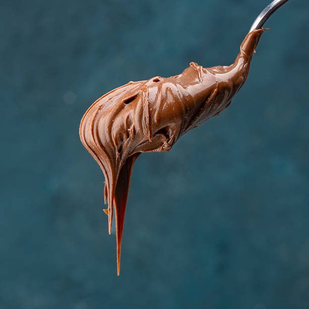 istock Cream chocolate in a spoon on a vintage background 2242338105