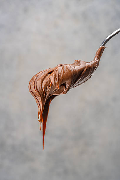 istock Cream chocolate in a spoon on a vintage background 2242338107