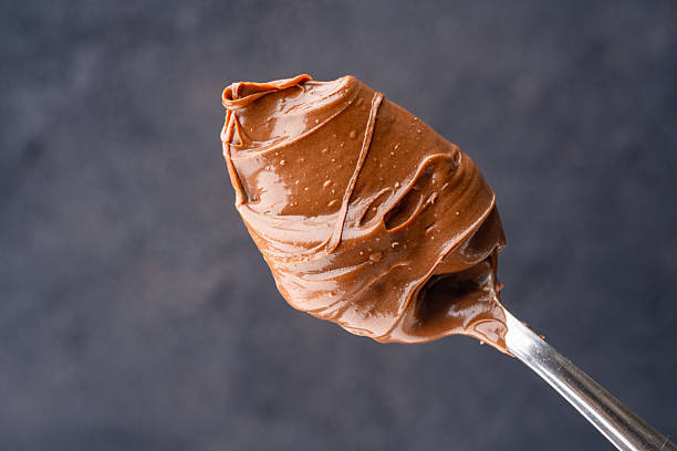 istock Cream chocolate in a spoon on a black background 2242338141