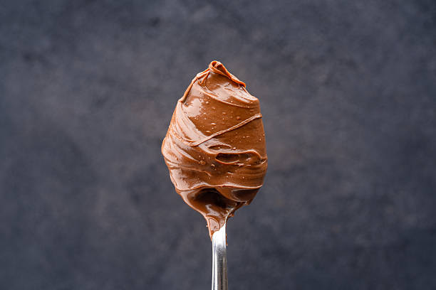 istock Cream chocolate in a spoon on a black background 2242338142