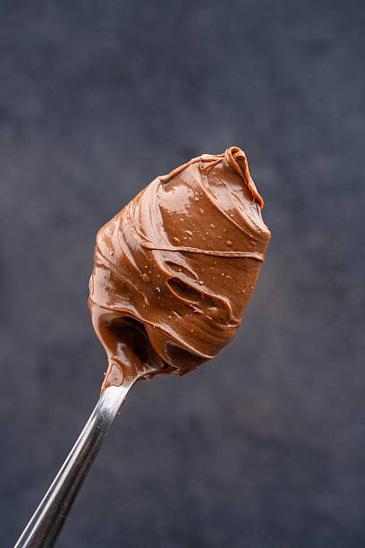 istock Cream chocolate in a spoon on a black background 2242338144