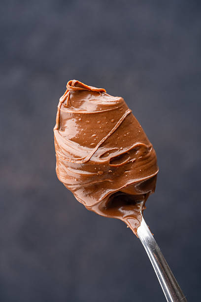 istock Cream chocolate in a spoon on a black background 2242338177