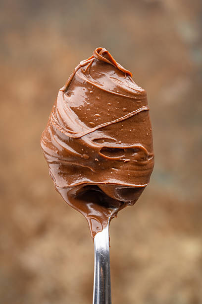 istock Cream chocolate in a spoon on a vintage background 2242338181