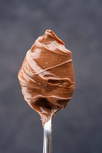istock Cream chocolate in a spoon on a black background 2242338183