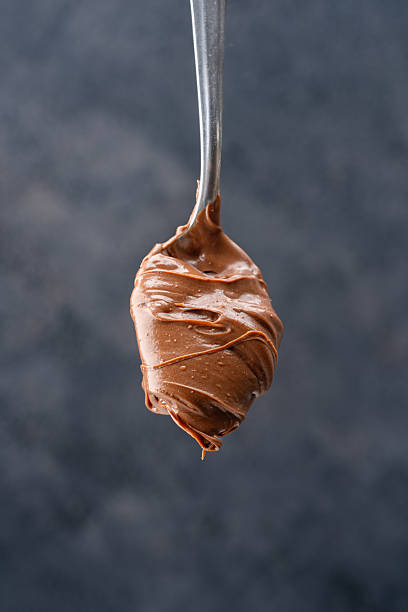 istock Cream chocolate in a spoon on a black background 2242338194