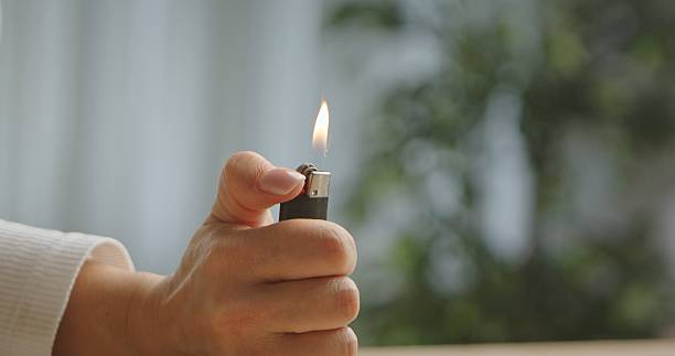 istock Close up of Hand Holding a Lit Lighter 2242338901