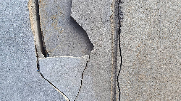 istock white concrete wall has cracks due to poor quality construction. Cracked wall surface, earthquake cracked. 2242339575