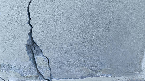 istock white concrete wall has cracks due to poor quality construction. Cracked wall surface, earthquake cracked. 2242339908