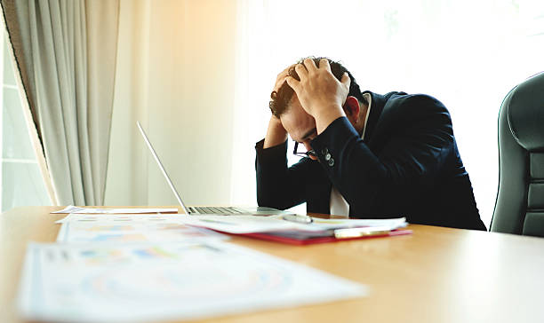 istock Emotional state, work-related problems and accumulated stress and anxiety. Businessman at a desk with documents. 2242340534