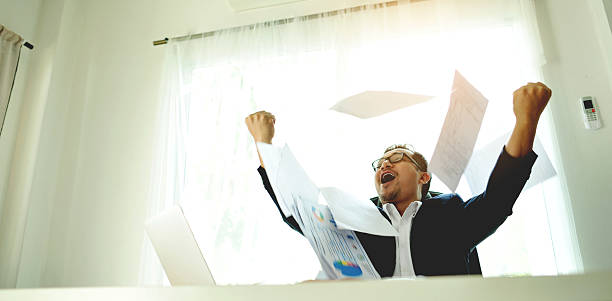 istock Successful business people throwing papers celebrating and enjoying their work, financial planning and investing, working on financial documents. 2242340593