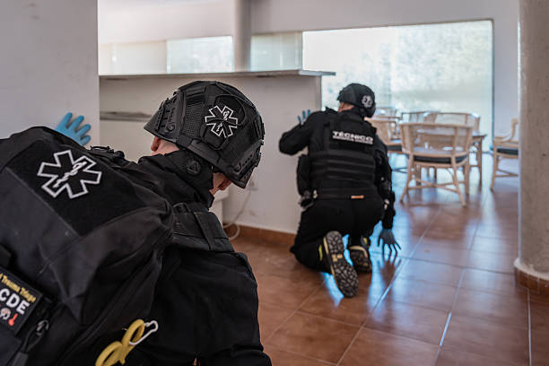 Paramedics wearing tactical gear and helmets searching a building during an emergency response