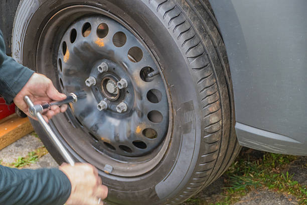 The man replacing the tire on the truck.