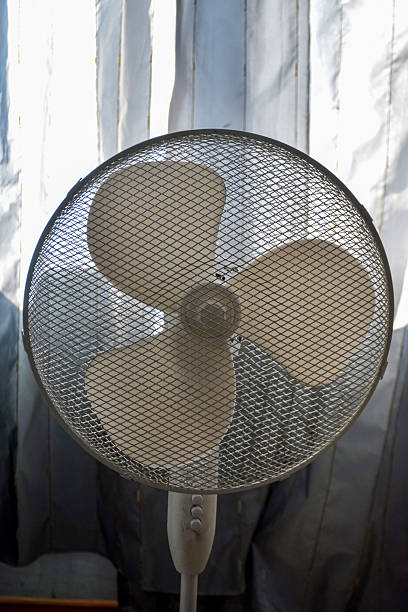 Dirty white pedestal fan in room