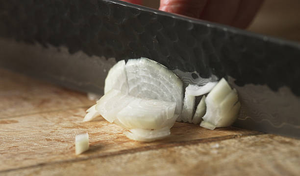 istock Female Chef Slicing Onion on Wooden Cutting Board. 2242350411