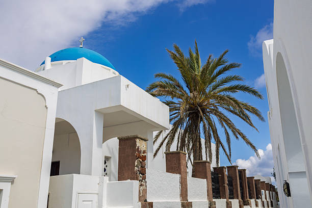 Traditional Blue Domed Church and Palm Tree in Santorini, Greece. 6 October 2025