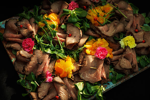Appetizer presentation with meat, greens, and colorful garnish. Excellent for catering, hospitality, or food styling projects.