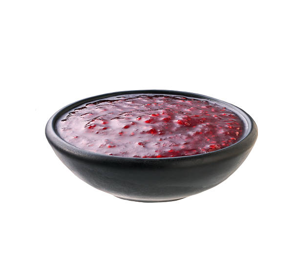 istock raspberry jam in a black bowl isolated on white background. 2242356503