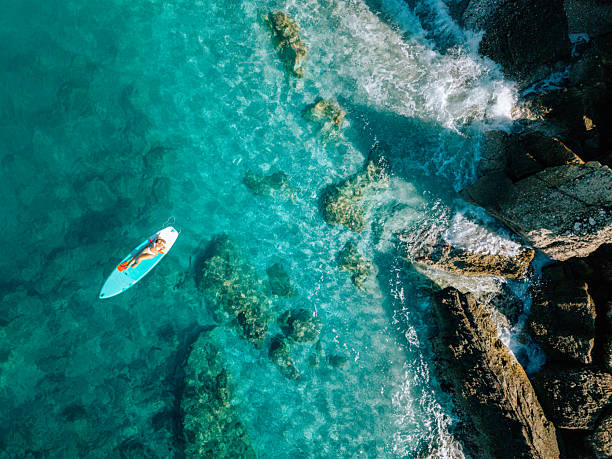 istock Top-Down View: Woman Lying on Paddleboard in Turquoise Sea 2242356665