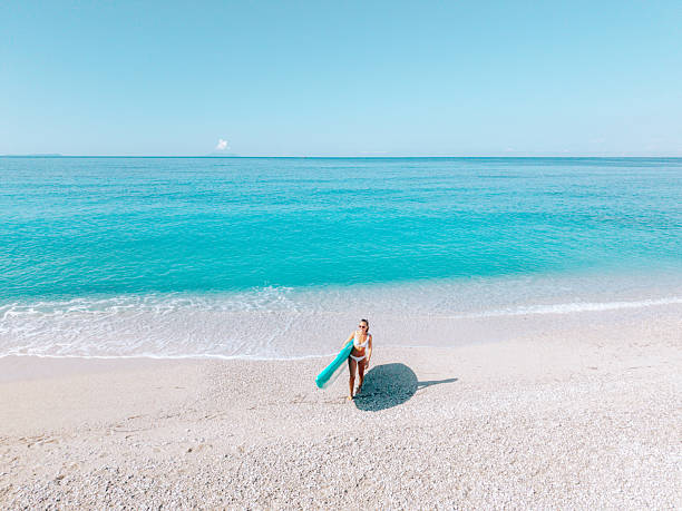 istock Woman Standing in Shallow Ocean Water with Paddleboard 2242356722