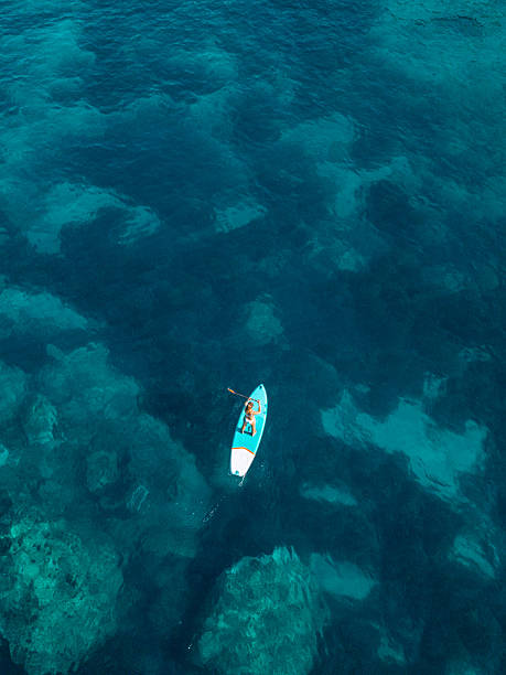 istock Top-Down View: Woman Lying on Paddleboard in Turquoise Sea 2242356883