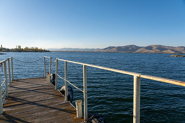 istock Rustic Wooden Dock on the Calm Lake with Mountainous Background 2242358366