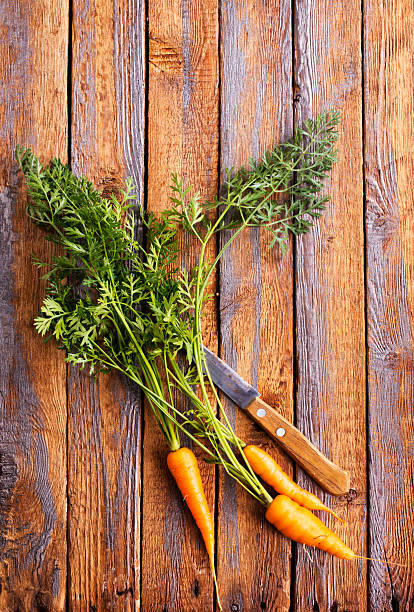 raw carrots on a wooden background