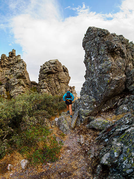 Mountaineer among crags overcoming the difficulties of the trail. Batuecas Valley. Sierra de Francia