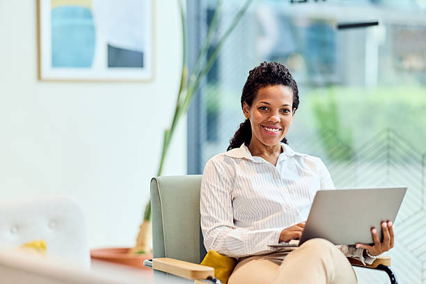 istock African-American Woman Smiling While Working On Laptop In Modern Office Setting, Professional Portrait 2242366248